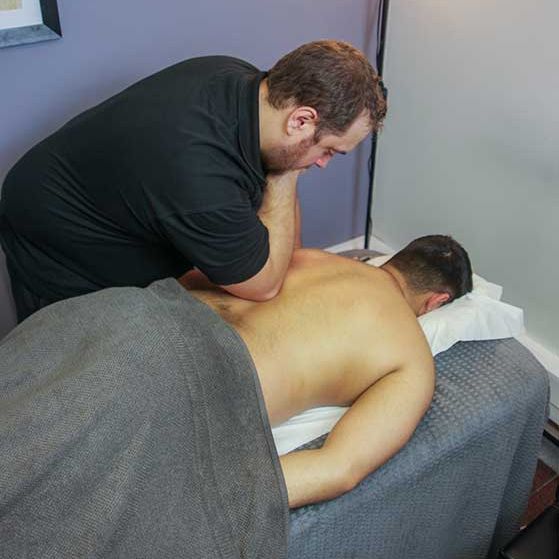 James Egginton applying deep tissue sports massage to a client's back